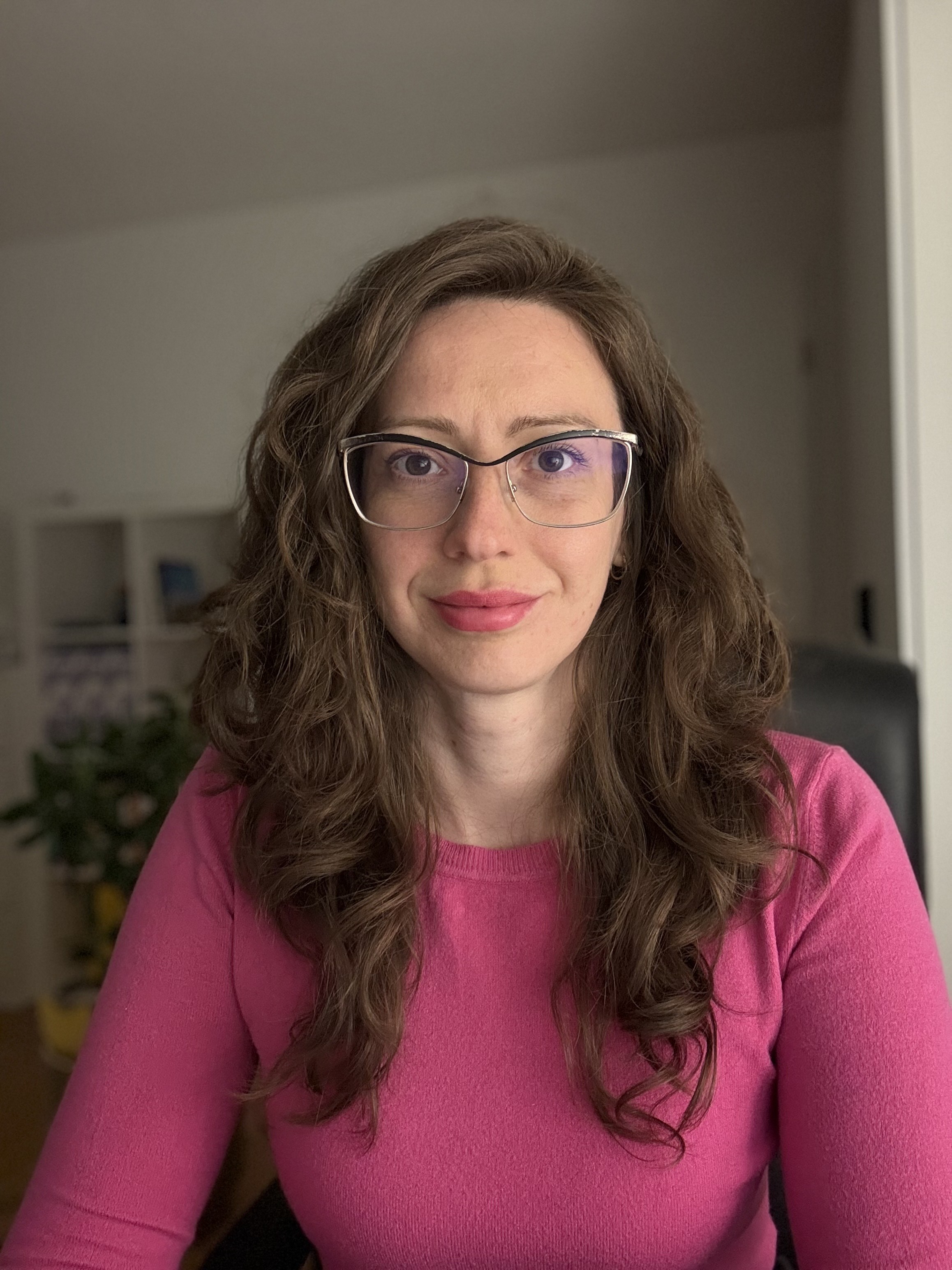  Portret Coachki  rozwoju osobistego Endorfina Życia - wsparcie w odzyskaniu spokoju,sensu i równowagi w życiu. Uśmiechnięta kobieta, ma na sobie różowy sweter i okulary.